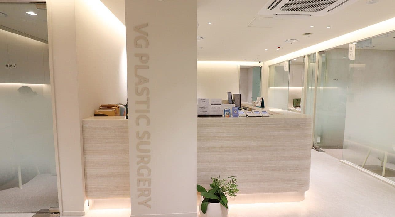 A column with vertical VG PLASTIC SURGERY signage, beside the entrance to a VIP consultation room