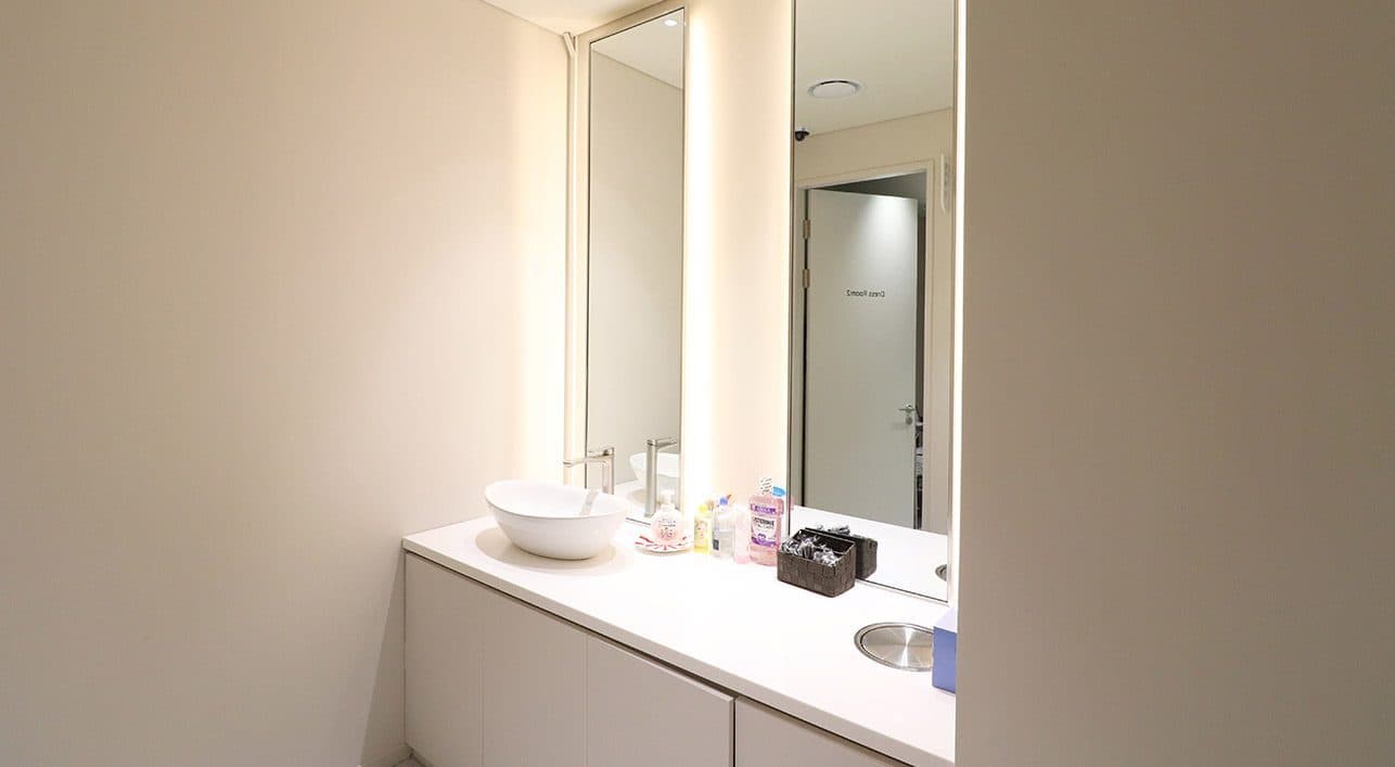 A powder room with a basin and a backlit mirror